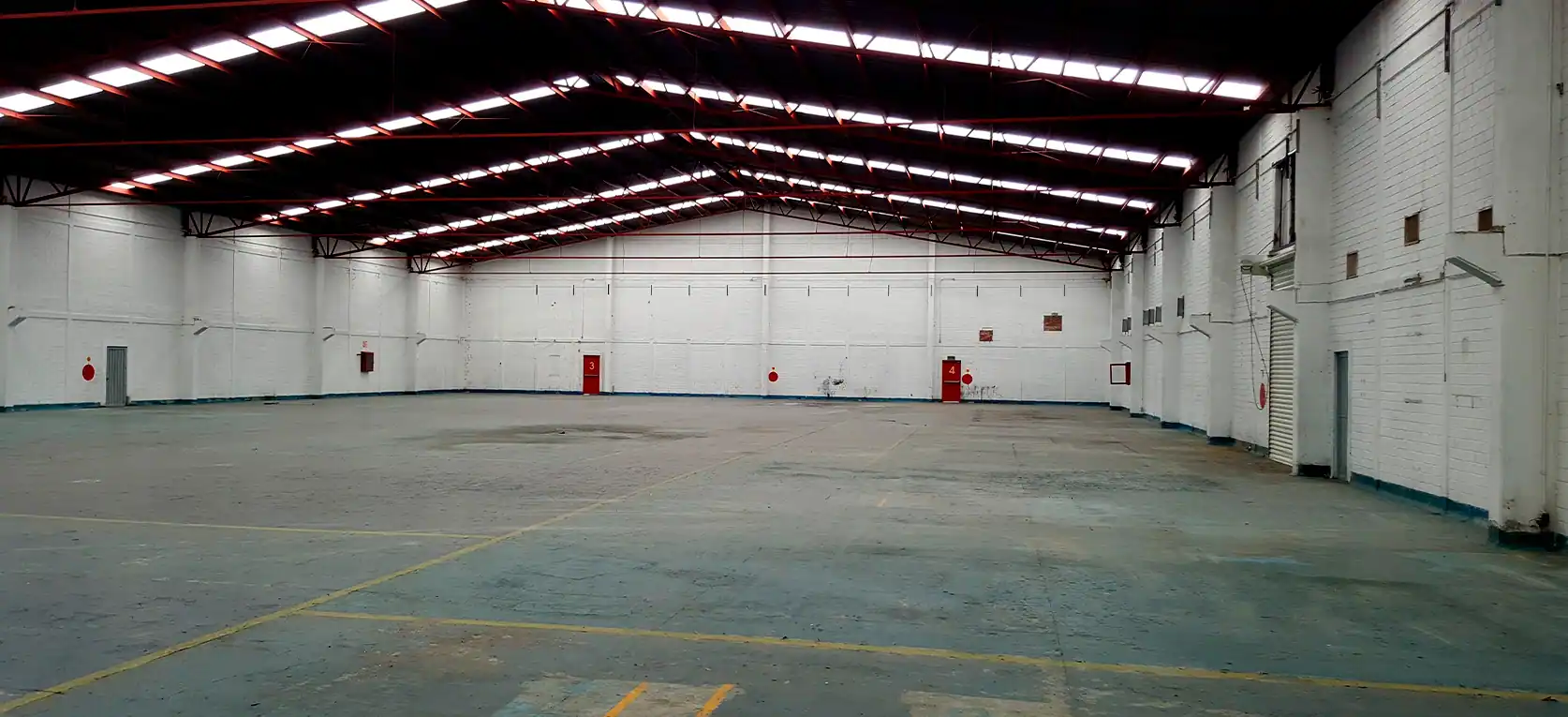 Interior de bodega industrial con muros de block y techo de lámina en Exportec