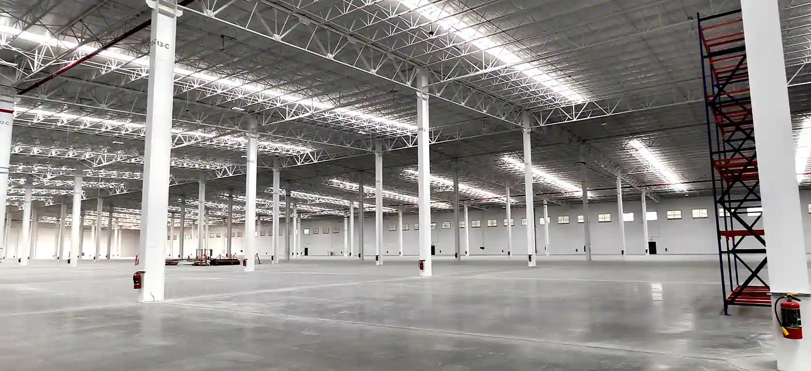 Interior de nave industrial con lámparas LED y piso de concreto en Lerma